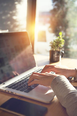 Tradesman typing on laptop getting their indemnity insurance